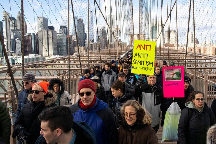People take part in a march crossing the Brooklyn Bridge in solidarity with the Jewish community after recent string of anti-semitic attacks throughout the greater New York area, on in New York